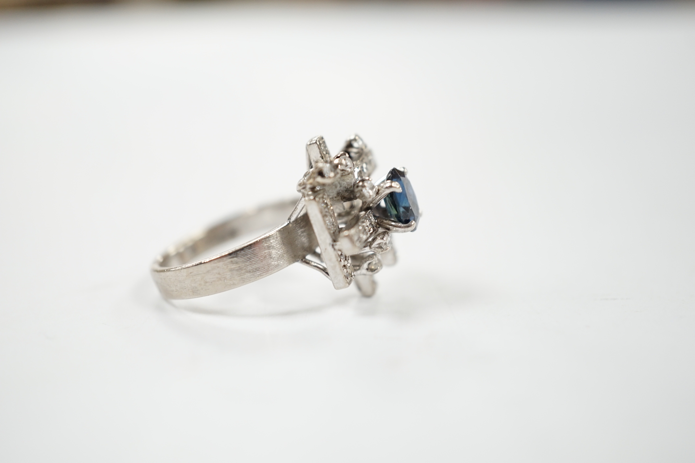 A modern 18k white metal, sapphire and diamond set modernist ring, size K/L, gross weight 6.1 grams.
